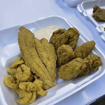 A seafood meal with sides and tartar sauce.